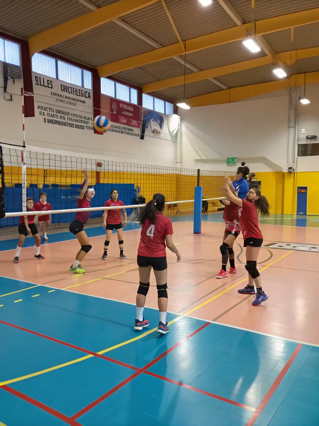 Teenagers playing volleyball in a gymnasium, focusing on teamwork and coordination, under the guidance of a skilled instructor.
